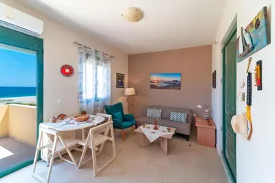 a living room with a table and a couch at Mare Blu 2 on the beach in Gennadi