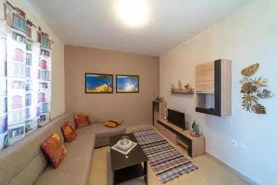 a living room with a couch and a tv at Mare Blu 2 on the beach in Gennadi