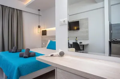 a bedroom with a blue bed and a mirror at Casa Stavris in Faliraki