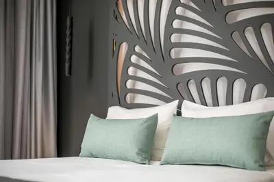a bedroom with a bed with green and white pillows at Casa Stavris in Faliraki