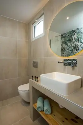 a bathroom with a sink and a toilet and a mirror at Casa Stavris in Faliraki