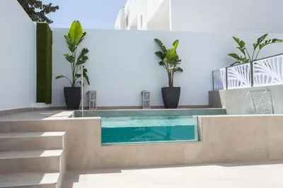 a swimming pool in a house with potted plants at Casa Stavris in Faliraki