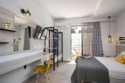a bedroom with a bed and a desk with a yellow chair at Casa Stavris in Faliraki
