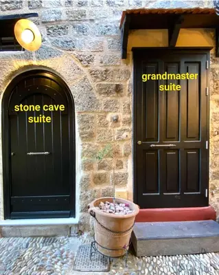 a building with two doors and a flower pot in front at Grand Master Suite in Rhodes Town