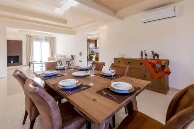 a dining room with a wooden table and chairs at Lucia's Secret Garden in Asgourou