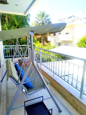 a chair on a balcony with an umbrella at Holiday Nest & parking in Ialyssos