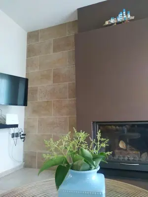 a blue vase with a plant in front of a fireplace at Holiday Nest & parking in Ialyssos