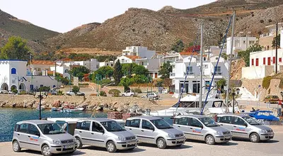 a group of cars parked in a parking lot near the water at Stefanakis Villas - Car Included in Livadia