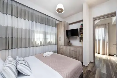 a bedroom with a bed with two pillows and a tv at Sun's Reach Villa in Rhodes Town
