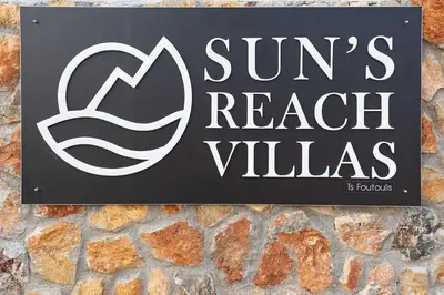 a sign for a beach villas sign on a stone wall at Sun's Reach Villa in Rhodes Town