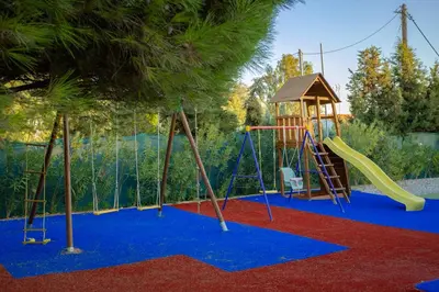 a playground with a slide and a swing set at Sun's Reach Villa in Rhodes Town