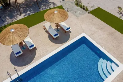 an overhead view of a swimming pool with umbrellas and chairs at Sun's Reach Villa in Rhodes Town