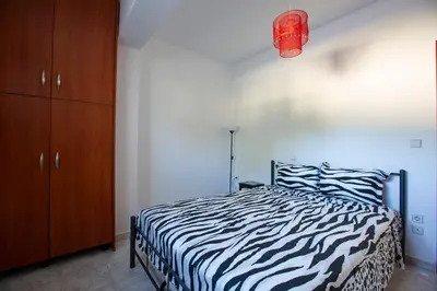 a zebra print bed in a bedroom with a brown cabinet at Natural Quiet Accommodation in Kallithea Rhodes