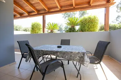 a table and chairs on a balcony with plants at Natural Quiet Accommodation in Kallithea Rhodes