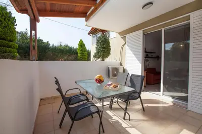 a glass table and chairs on a patio at Natural Quiet Accommodation in Kallithea Rhodes