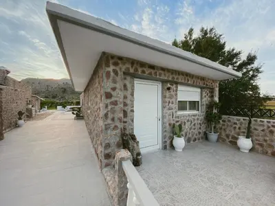 a stone house with a white door and a patio at LA Casa Di Lusso N4 - Adults Only in Kolimbia