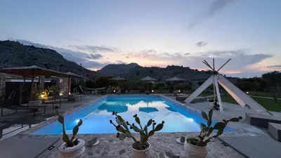 a swimming pool with cacti in potted plants in front of a sunset at LA Casa Di Lusso N4 - Adults Only in Kolimbia