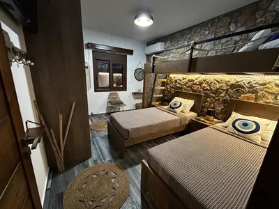 a room with two beds and a bunk bed at Aithonas Villa in Archangelos