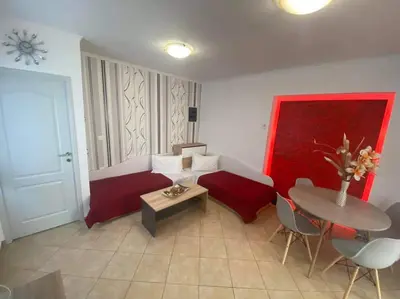 a living room with a red couch and a table at Faliraki Holidays in Faliraki