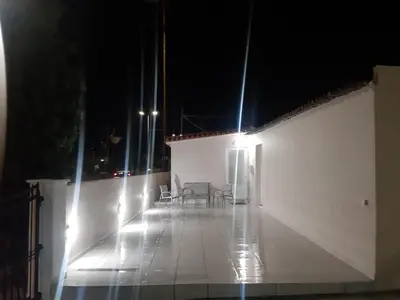 a balcony at night with chairs and lights at Faliraki Holidays in Faliraki