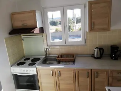 a kitchen with a stove and a sink and two windows at Faliraki Holidays in Faliraki