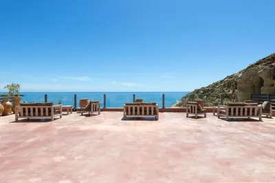 a group of benches sitting on a patio overlooking the ocean at Stone Luxury Suites - Adults Only in Archangelos