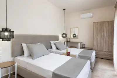 a bedroom with a large white bed and a couch at ANASTASIOS HOUSE STEGNA in Archangelos