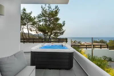 a hot tub on the balcony of a house at ANASTASIOS HOUSE STEGNA in Archangelos
