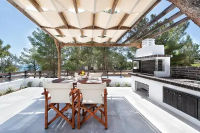 a patio with a table and chairs under a pergola at ANASTASIOS HOUSE STEGNA in Archangelos