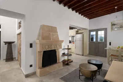 a living room with a fireplace and a kitchen at Mami`s House with Private Pool in Pefki Rhodes