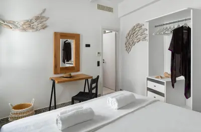 a white bedroom with a bed and a mirror at Mami`s House with Private Pool in Pefki Rhodes