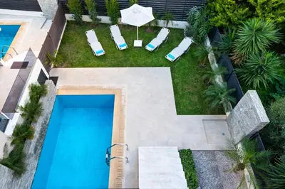 an overhead view of a swimming pool with chairs and an umbrella at Ixia Breeze 1 in Ixia