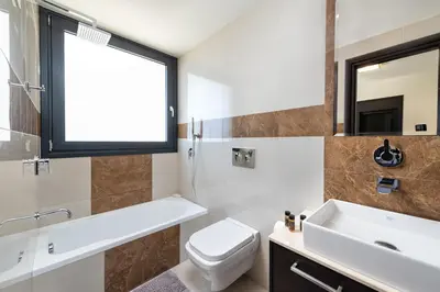 a bathroom with a sink toilet and a window at Ixia Breeze 1 in Ixia