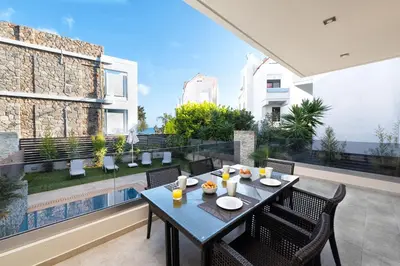a dining table on the balcony of a house at Ixia Breeze 1 in Ixia