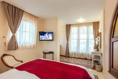 a bedroom with a large bed with a red blanket at In Camera Art Boutique Hotel in Rhodes Town