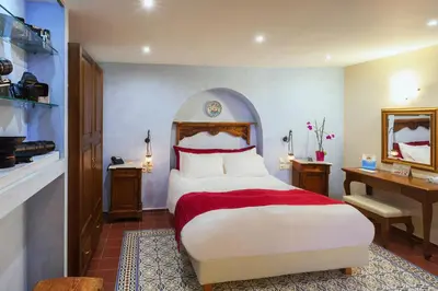 a bedroom with a bed with a red and white bedspread at In Camera Art Boutique Hotel in Rhodes Town