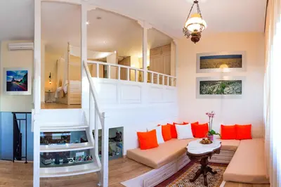 a living room with a staircase and orange pillows at In Camera Art Boutique Hotel in Rhodes Town