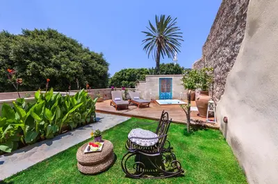 a garden with a patio with a table and chairs at In Camera Art Boutique Hotel in Rhodes Town