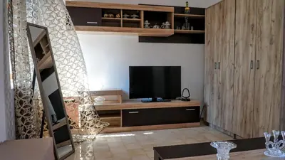 a living room with a television on a wooden cabinet at Armonia House in Symi