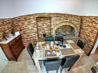 a dining room with a table and a brick wall at Armonia House in Symi