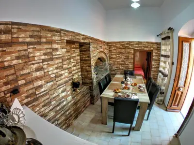 a dining room with a brick wall and a table at Armonia House in Symi