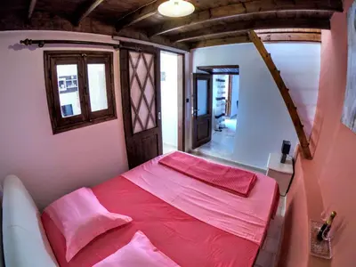 a bedroom with a red bed in a room at Armonia House in Symi