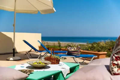 a table with a bowl of food on it with the beach at House Myrtos in Lachania