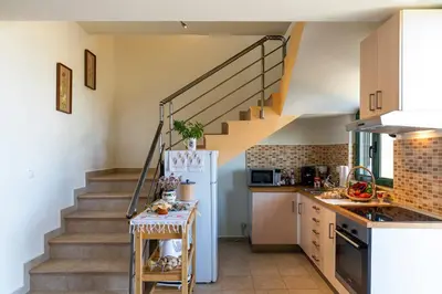 a kitchen with a staircase and a refrigerator at House Myrtos in Lachania