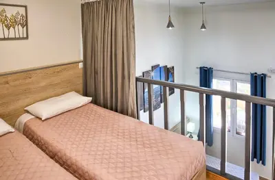 a bedroom with two beds and a balcony at Haraki Sand Beach in Haraki
