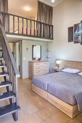 a bedroom with a large bed and a staircase at Haraki Sand Beach in Haraki