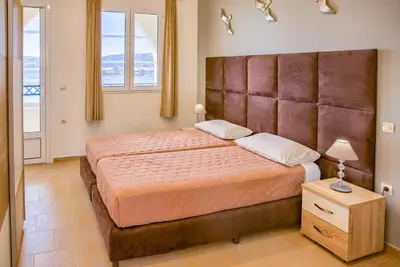 a bedroom with a large bed with a large headboard at Haraki Sand Beach in Haraki