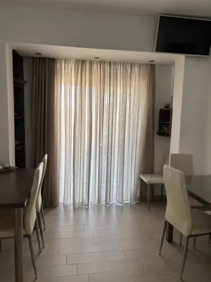 a dining room with a table and a large window at Haraki Beauty in Haraki