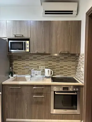 a kitchen with wooden cabinets and a sink and a microwave at Haraki Beauty in Haraki