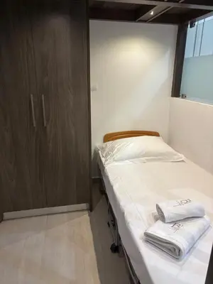 a small bedroom with a bed with towels on it at Haraki Beauty in Haraki